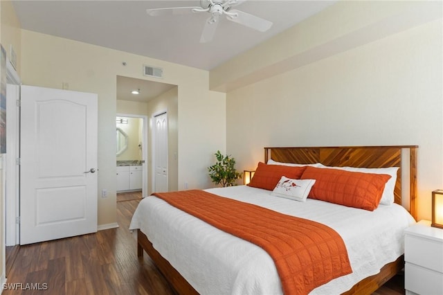 bedroom with a closet, visible vents, ceiling fan, ensuite bath, and wood finished floors