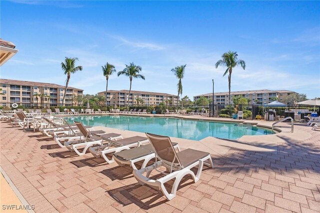 pool with a patio area and fence