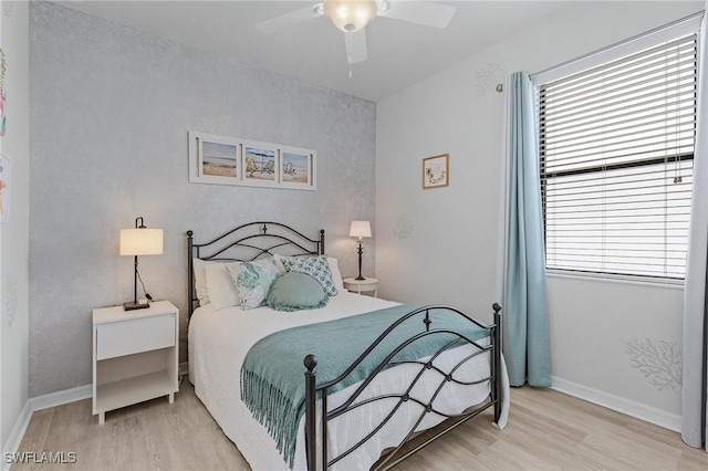 bedroom with a ceiling fan, baseboards, and wood finished floors