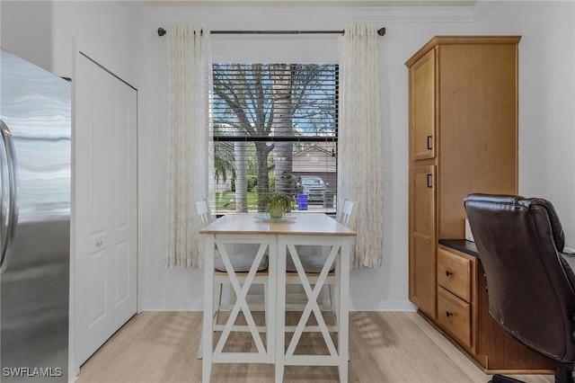 home office with ornamental molding and light wood finished floors