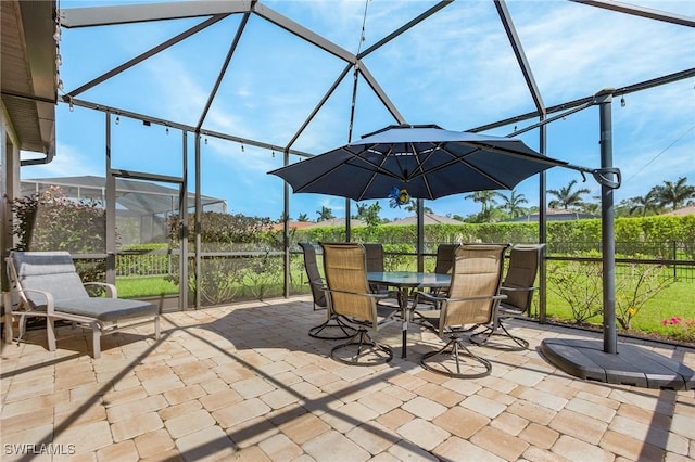 view of patio / terrace with outdoor dining space, a lanai, and fence