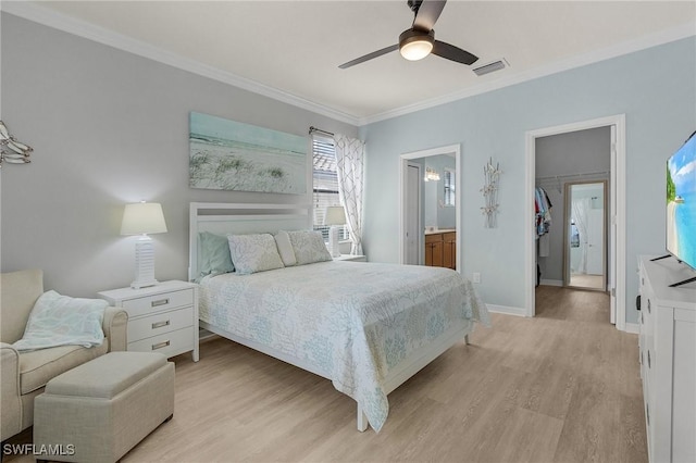 bedroom featuring baseboards, visible vents, a spacious closet, crown molding, and light wood-type flooring