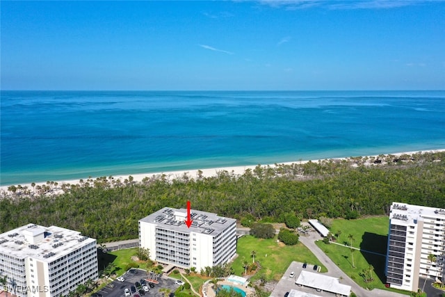 birds eye view of property with a water view and a beach view