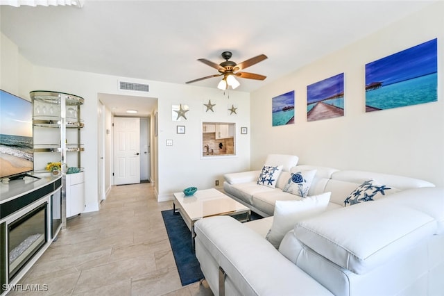 living area featuring a ceiling fan, visible vents, and baseboards