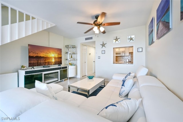 living area featuring visible vents and ceiling fan