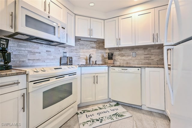 kitchen featuring tasteful backsplash, white appliances, and white cabinets