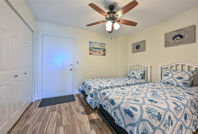 bedroom featuring ceiling fan, a closet, and wood finished floors