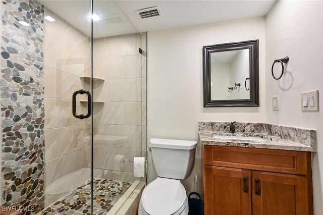 bathroom featuring a stall shower, visible vents, vanity, and toilet