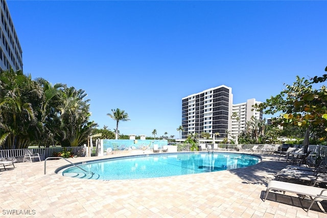 community pool featuring fence and a patio