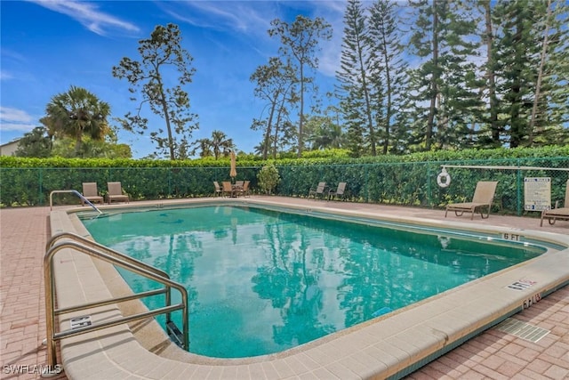 pool with fence and a patio