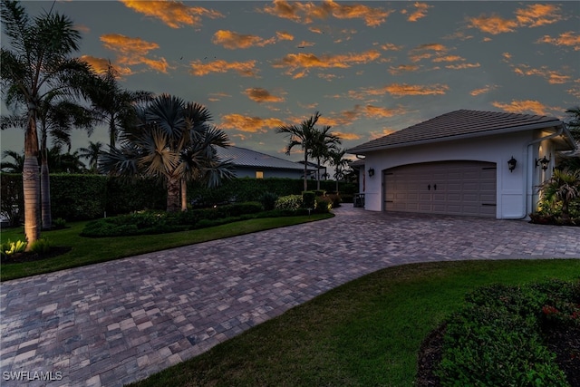 1015 Goldenrod Ave, Marco Island, FL 34145 - view of front of home with a garage, a tiled roof, decorative driveway, a front lawn, and stucco siding