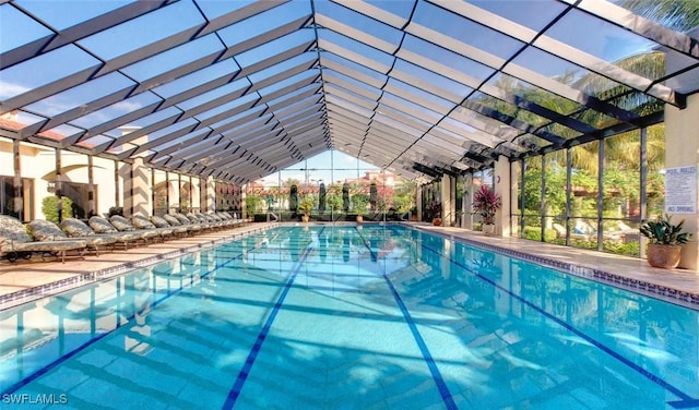 community pool featuring glass enclosure and a patio