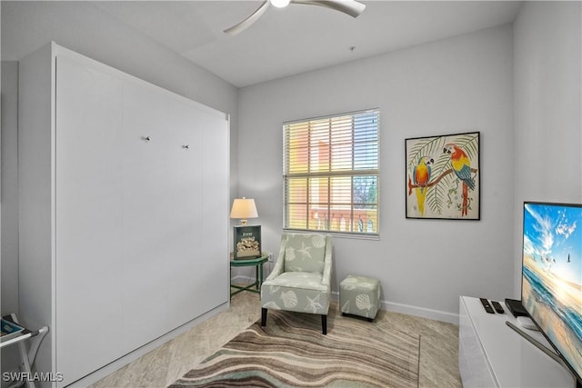 sitting room featuring baseboards and a ceiling fan