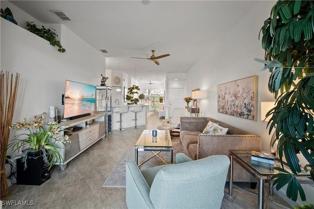 living area with ceiling fan and visible vents