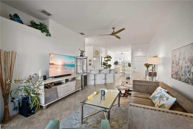 living area with ceiling fan and visible vents