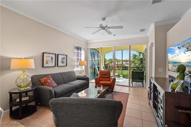 living area with light tile patterned floors, ceiling fan, visible vents, and ornamental molding