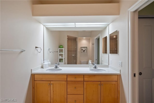 full bath featuring double vanity, tiled shower, and a sink