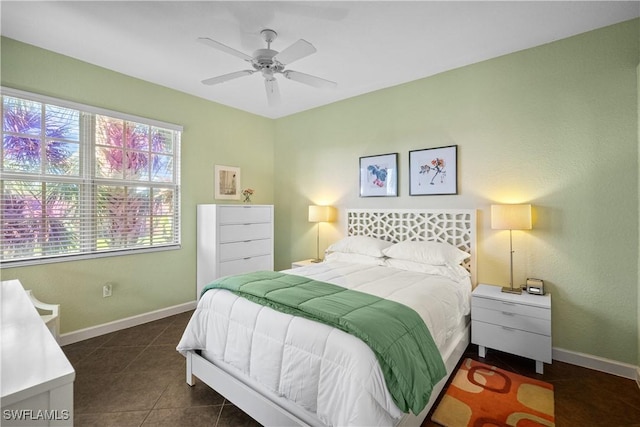 bedroom with ceiling fan, baseboards, and dark tile patterned flooring