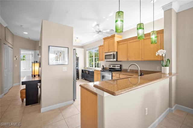 kitchen featuring a peninsula, crown molding, stainless steel appliances, and baseboards