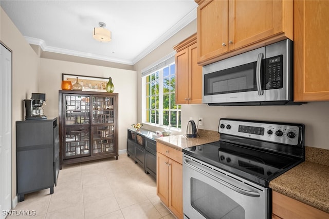 kitchen with ornamental molding, light tile patterned floors, light stone countertops, baseboards, and appliances with stainless steel finishes