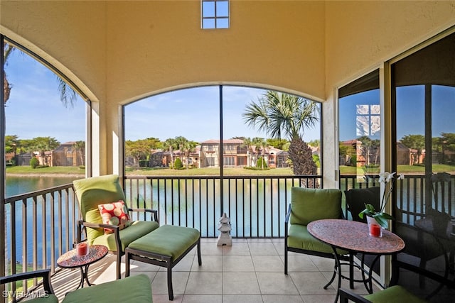 sunroom / solarium featuring a water view and a residential view