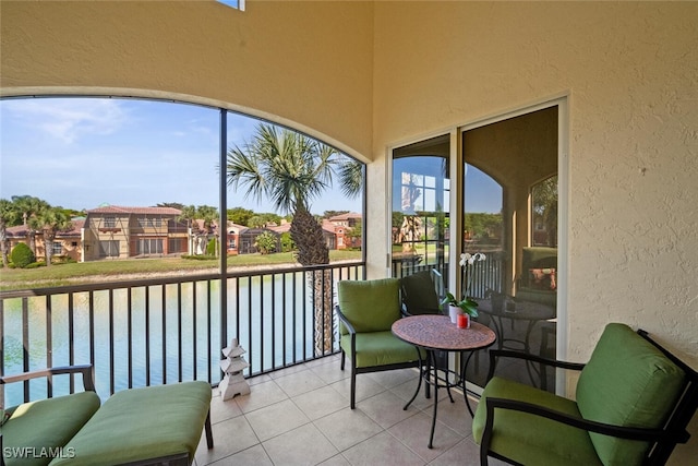 sunroom / solarium featuring a water view, a residential view, and a healthy amount of sunlight