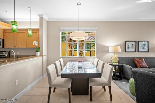 dining room featuring baseboards, ornamental molding, and light tile patterned floors