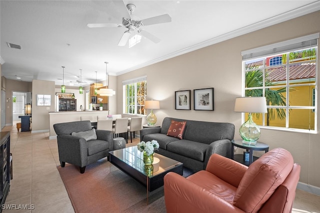 living room featuring light tile patterned floors, baseboards, visible vents, and ornamental molding