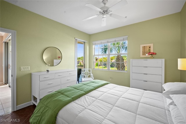bedroom with a ceiling fan, baseboards, and dark tile patterned flooring