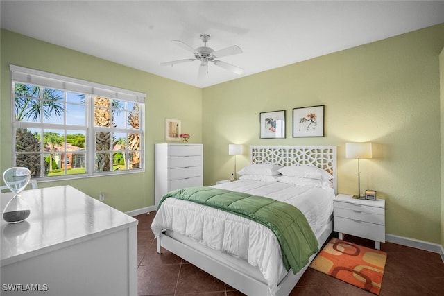 bedroom with dark tile patterned flooring, baseboards, and a ceiling fan