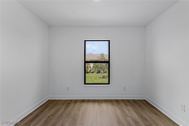 unfurnished room featuring wood finished floors and baseboards