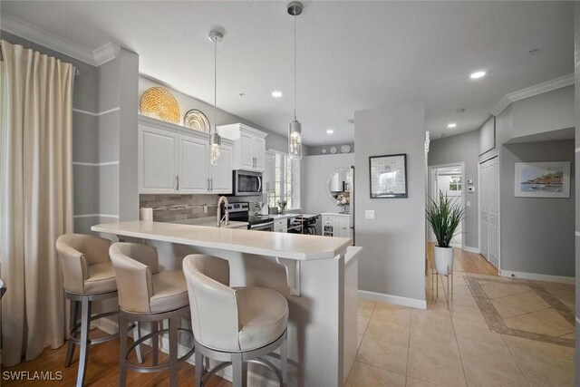 kitchen with tasteful backsplash, recessed lighting, light countertops, appliances with stainless steel finishes, and baseboards