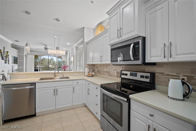 kitchen with light tile patterned floors, decorative backsplash, appliances with stainless steel finishes, white cabinetry, and a sink