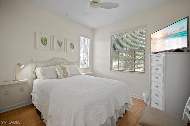 bedroom featuring ceiling fan, baseboards, and wood finished floors