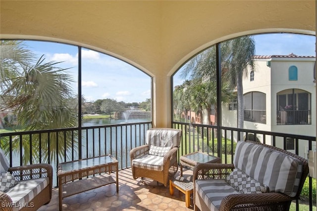 sunroom / solarium featuring a water view