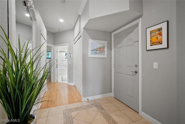 foyer with light tile patterned flooring and baseboards