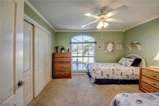 bedroom with ornamental molding, carpet, a closet, and a ceiling fan