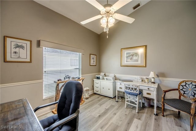 office space featuring baseboards, visible vents, a ceiling fan, vaulted ceiling, and light wood-style floors