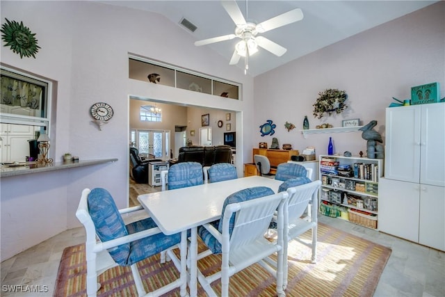 dining space with high vaulted ceiling, visible vents, and ceiling fan with notable chandelier