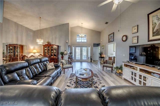 living area with french doors, visible vents, high vaulted ceiling, light wood-type flooring, and ceiling fan with notable chandelier