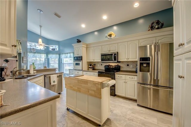 kitchen featuring decorative light fixtures, stainless steel appliances, visible vents, backsplash, and a sink