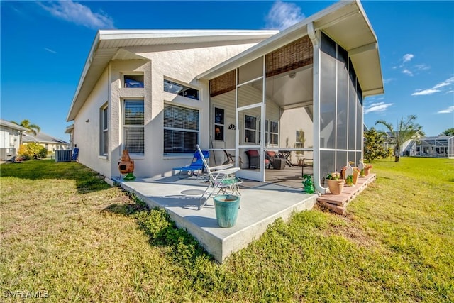 back of house with a patio area, central AC unit, a lawn, and stucco siding