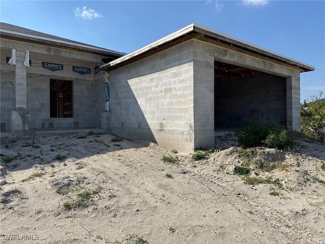 view of property exterior featuring a garage and concrete block siding