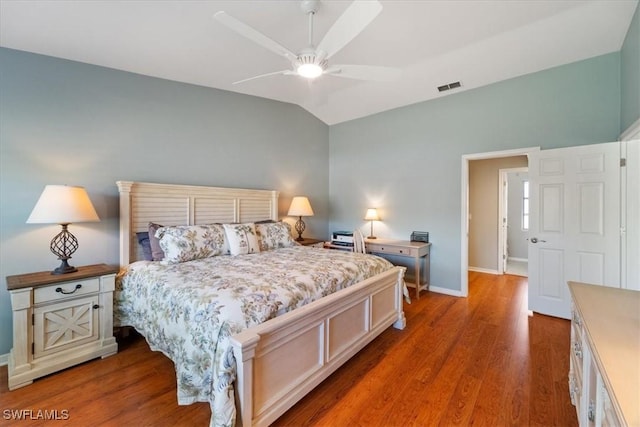 bedroom featuring wood finished floors, a ceiling fan, visible vents, vaulted ceiling, and baseboards