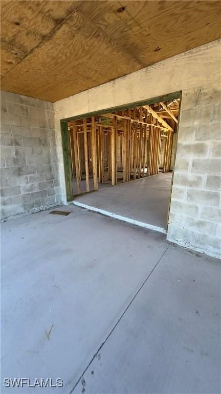 miscellaneous room featuring concrete flooring and concrete block wall