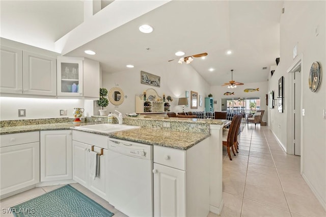 kitchen featuring light tile patterned floors, ceiling fan, a peninsula, a sink, and dishwasher