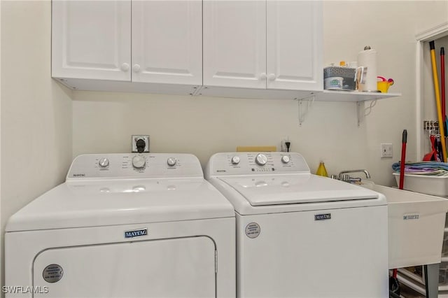 clothes washing area featuring washer and dryer and cabinet space