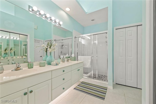 full bath featuring a stall shower, tile patterned flooring, a closet, and a sink