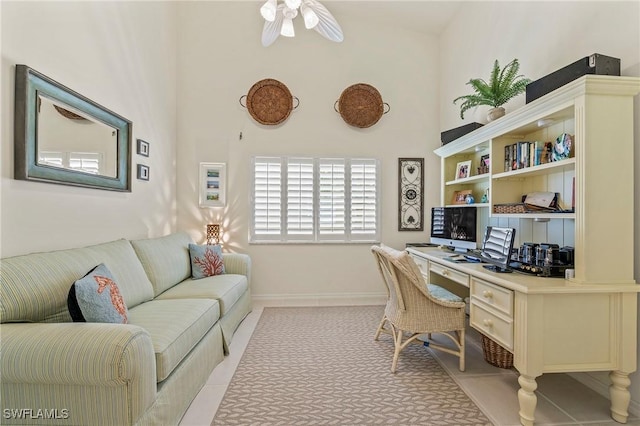 home office featuring built in study area, ceiling fan, and baseboards