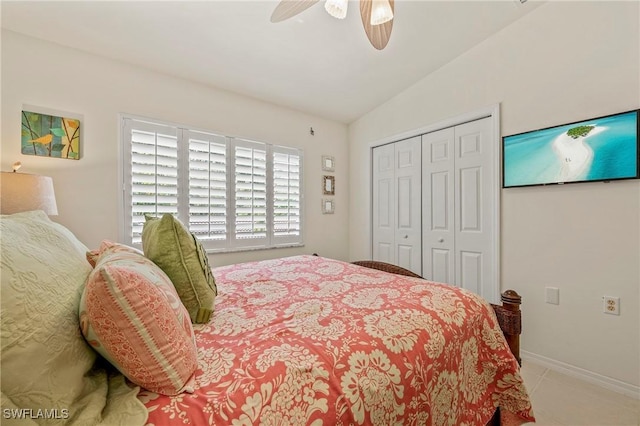 bedroom featuring baseboards, ceiling fan, tile patterned floors, vaulted ceiling, and a closet